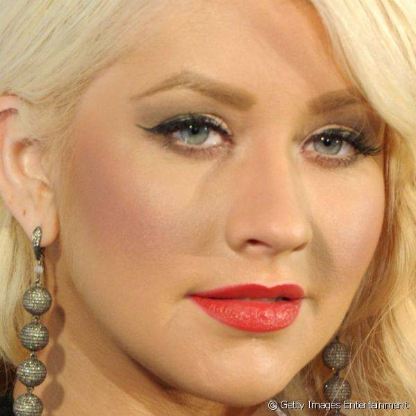 Christina investiu na sua maquiagem tradicional de olhos destacados por c?lios e delineador, blush bem marcado e batom vermelho para a promo??o de seu perfume 